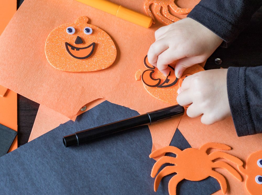 Tips til årets halloweenfeiring! 1 Barn som lager halloween dekorasjoner med orange papp