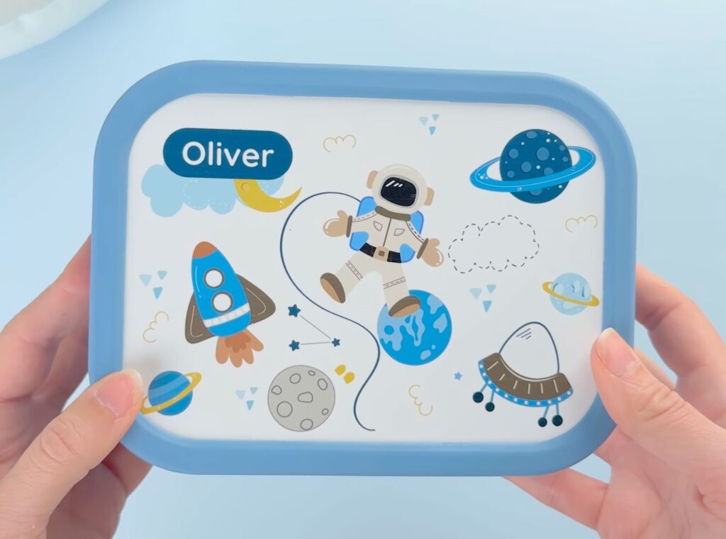 Stor matboks til barn – når trenger du det, og hva får plass? 2 Blå matboks med astronaut-design og teksten oliver