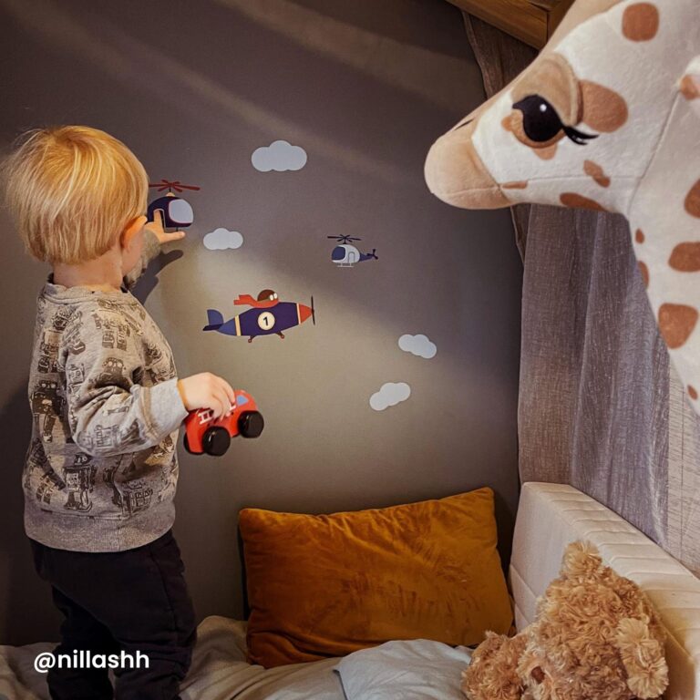 gutt som ser på klistremerkene på veggen