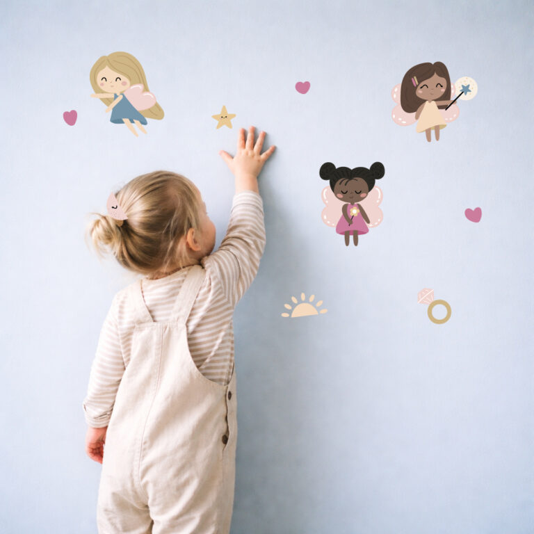 jente som fester fe-klistremerker på veggen