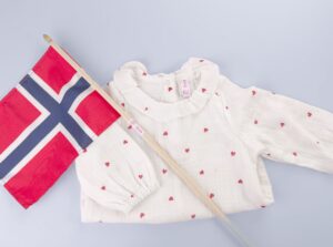 17. mai flagg merket med navnelapp, sammen med en penbluse til barn